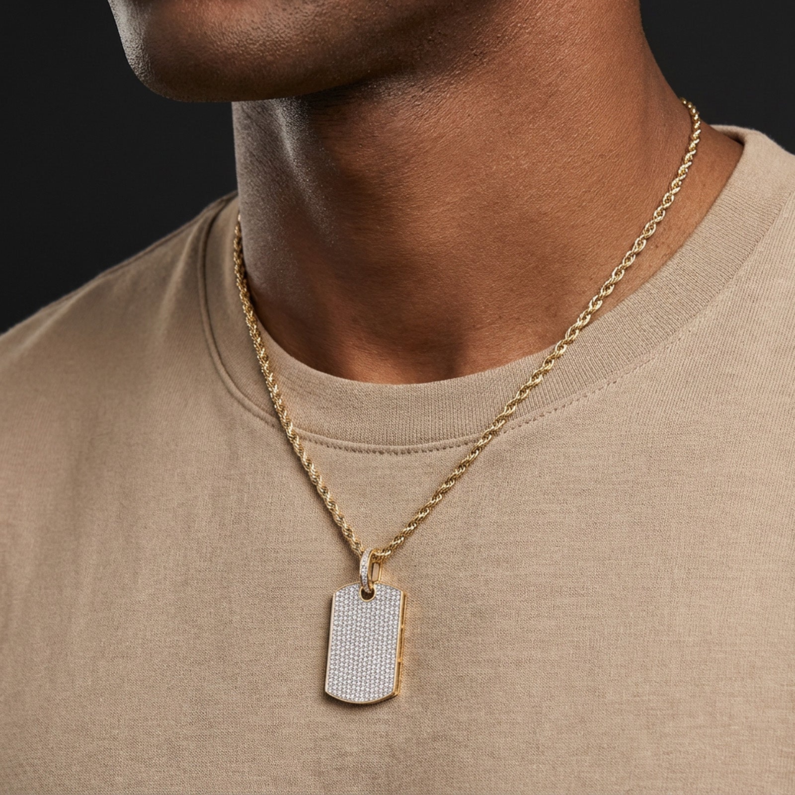 Man wearing a gold chain with a diamond-studded pendant on a plain background